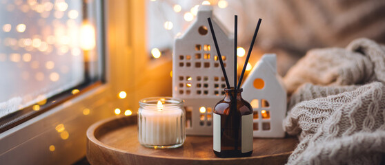 Banner. Christmas home aromatherapy. Cozy atmosphere, holiday spirit. Winter inspiration. Aroma diffuser with pine extract, organic essential oil, vanilla, gingerbread cookies, candles on wooden table