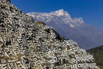 Nepal sacred stones mani with mantra written and carved on the surface. Prayer stones shire on the...