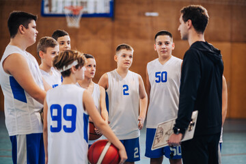 A junior basketball team with their coach at indoor court on training.