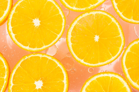 Orange fruit slices on pink background. Summer fruit close up concept.