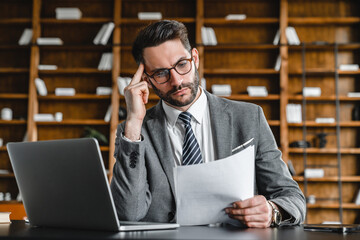 Stressed young businessman having hard issue problem with documents in office. Canceled payment,...