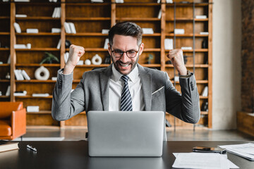 Successful young businessman achieving bonus, winning money working on laptop. Online bidding, gambling, placing bet and hitting jackpot in lottery casino. Deal, affirmations, positive changes