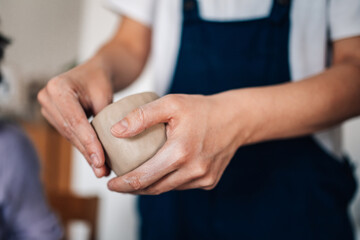 Close up of female artisan's hands modeling clay mug at ceramics studio