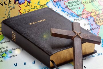 Holly bible book and cross on the map