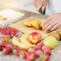 Person, hands and closeup of knife for fruit with breakfast in kitchen with cutting, healthy meal and nutrition in home. Cooking, wellness and preparation of organic brunch for detox and vegan diet