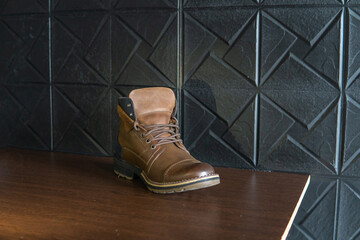Brown leather work boots on a wooden table on a rustic background