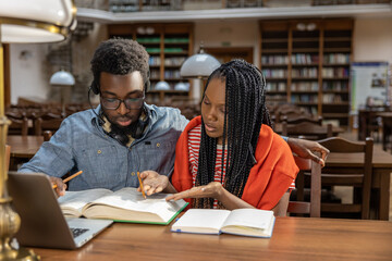 Dark-skinned couple studying together in the library