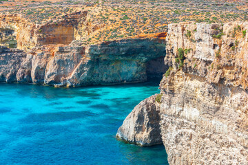 Naklejka premium Comino island in Malta features turquoise waters and rocky coastal formations