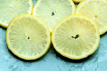 Pile of fresh lemon slices on blue plate