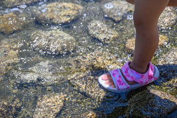 水に濡れる子供の足