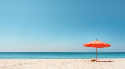 Orange umbrella on sandy beach with clear blue sky