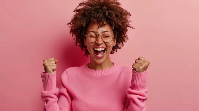 overjoyed woman celebrating success excited facial expression with raised fists lifestyle photo