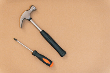 Hammer and screwdriver on a wooden background with copy space. Carpentry concept