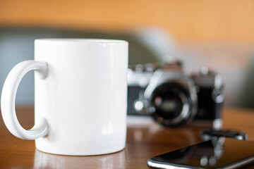 Vintage film camera and coffee mug on a wooden table