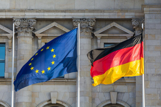 The flags of the European Union and Germany wave in front of the German parliament in Berlin