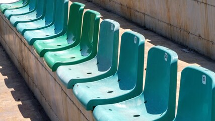 Fototapeta premium A row of green chairs are lined up in a row