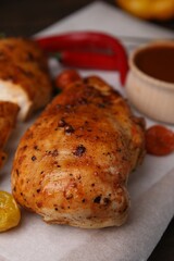 Baked chicken fillets and marinade on table, closeup