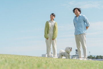 愛犬を可愛がる飼い主の親子・犬の散歩（父親と娘）
