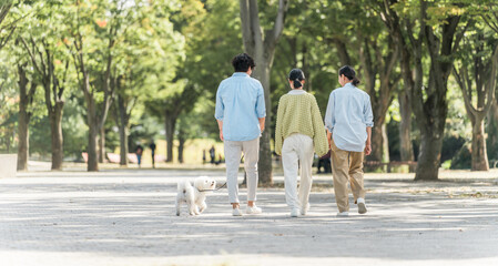 Fototapeta premium 犬・ペットと遊ぶ家族・ファミリー（両親と子供・3人） 