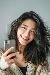Fototapeta premium A smiling woman is taking photo with her mobile phone