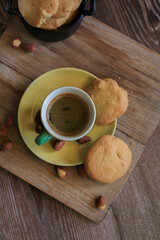 Coffee in green cup with cookies on the wooden table. Rustic wooden background. Cozy morning Breakfast at home or in a cafe.