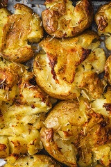 smashed baby potatoes on oven tray with rosemary and herbs