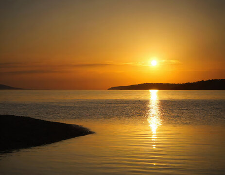 The stunning coastline and the silhouette of the island across the Aegean Sea at sunset	