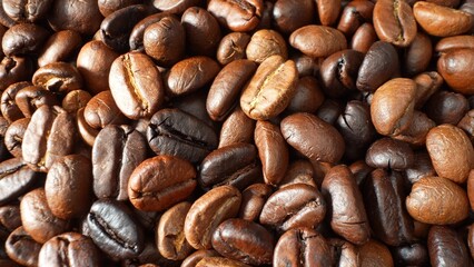 Behold the allure of roasted coffee beans, their glossy exterior hinting at a journey through flames. Cracks, like whispers of flavor, adorn each dark-brown gem, promising a symphony of taste.
