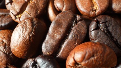 A roasted coffee beans in stunning close-up, where deep shades of brown interplay with glossy surfaces, unveiling the artistry of varied roasting levels and the promise of a perfect brew. 
