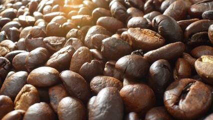 A mesmerizing close-up captures the rich essence of roasted coffee beans, showcasing an array of dark brown hues and gleaming textures, hinting at the diverse depths of roasting.
