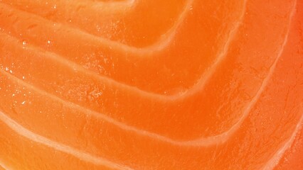 Precision meets perfection in this close-up of impeccably sliced salmon, showcasing its vibrant orange hue and intricate white marbling. Each slice epitomizes freshness and excellence.
