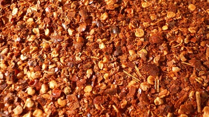 Zoom in on fiery ground chili, its coarse texture laden with seeds and flakes. The rich reddish-brown hue ignites the senses, promising an intense, spicy flavor experience.
