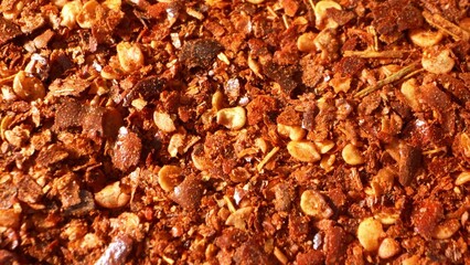 Up close, ground chili teases the eye with its fiery palette, a blend of passionate reds and robust browns. Its texture, a medley of flakes and seeds, promises a tantalizing, spicy experience.
