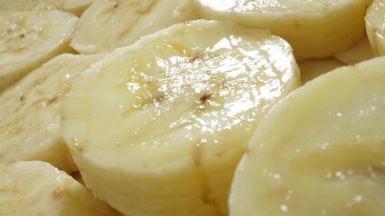 In this close-up, banana slices form a tantalizing heap, exuding a moist freshness that hints at their succulent taste. Their glossy surface reflects the essence of nature's sweetness.
