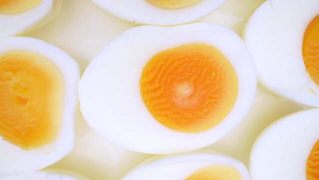Zoom in, the boiled eggs lay exposed, their halves revealing rich, yellow yolks nestled within pristine white shells. A touch reveals their firm texture, a testament to their hard-boiled perfection.
