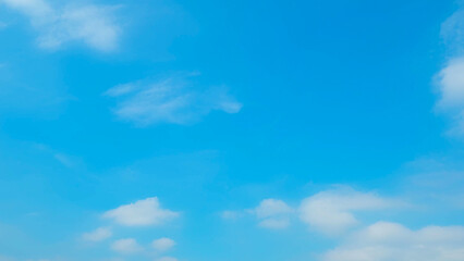A bright blue sky with a few scattered white clouds, creating a serene and peaceful atmosphere. The...