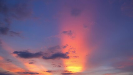 A captivating sunset with striking pink and orange rays illuminating the sky. The colors transition smoothly into purple and blue, with dark clouds adding contrast and depth. Sunset sky background.
