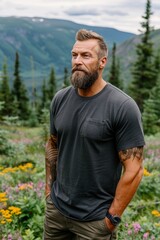 Bearded man in a dark t-shirt standing in a scenic mountain meadow with colorful flowers and pine trees