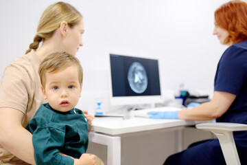 Toddler boy with his mom are at appointment with a pediatric neurologist. A mother tells an...