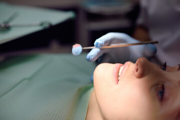 Dentist and patient at modern medical center. Doctor treats a young woman teeth in hospital....