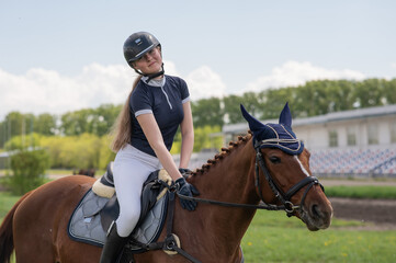 Portrait of a girl jockey riding a horse. 