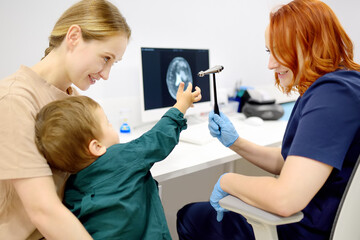 Baby and his mother are being seen by a pediatric neurologist in a modern medical clinic. Doctor...