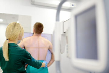 Female radiologist is making an Xray of lungs of patient in X-ray room of modern clinic. Doctor...