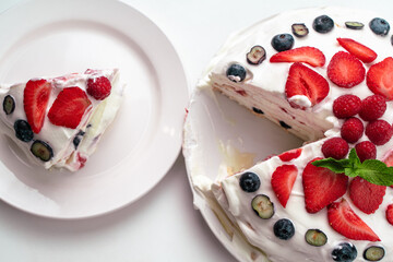 Homemade dessert Pavlova's meringue cake with mascarpone and berries on a white background.