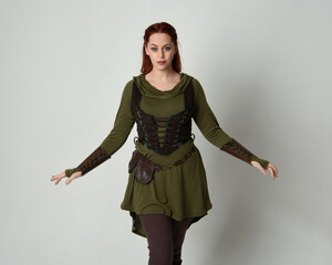 Close up portrait of beautiful  red haired female model, wearing green and brown medieval fantasy...