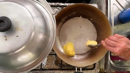 a woman roast cow butter organic healthy ghee in frying pan local people life cooking recipe in iran rural village scenic landscape top view of kitchen stove cooking food organic ingredient delicious