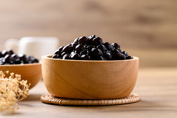Black tapioca pearls or boba in bowl on wooden background, Ingredient in bubble tea
