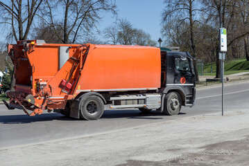 Garbage Truck Driving Down The City Street. Municipal Recycling Waste And Trash Services