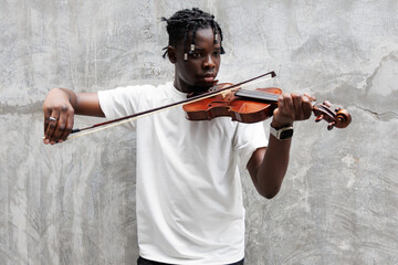 African American young man playing on violin. © winnievinzence