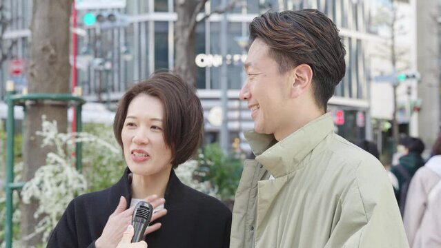 街頭インタビューを受ける男女